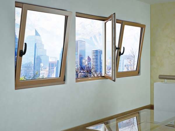 Serie de tres ventanas oscilobatientes de Sabaya en color madera, dos en apertura superior y una en modo abatible, mostrando sus diferentes posiciones de uso.