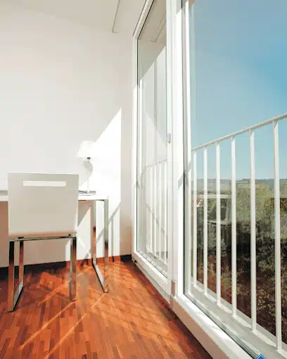 Cerramiento de balcón con correderas de cristal y suelo de madera con vistas al mar