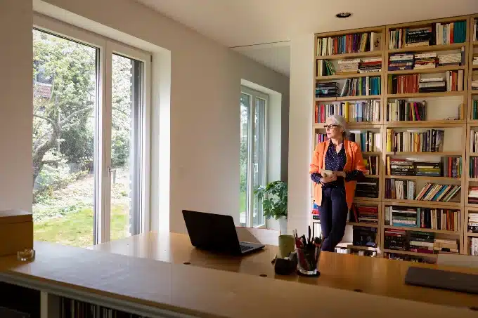 Interior con ventanas de PVC blancas que dejan entrar la luz junto a una librería